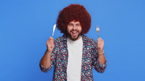 hungry man waiting for serving dinner meal dishes with restlessness holding cutlery fork knife