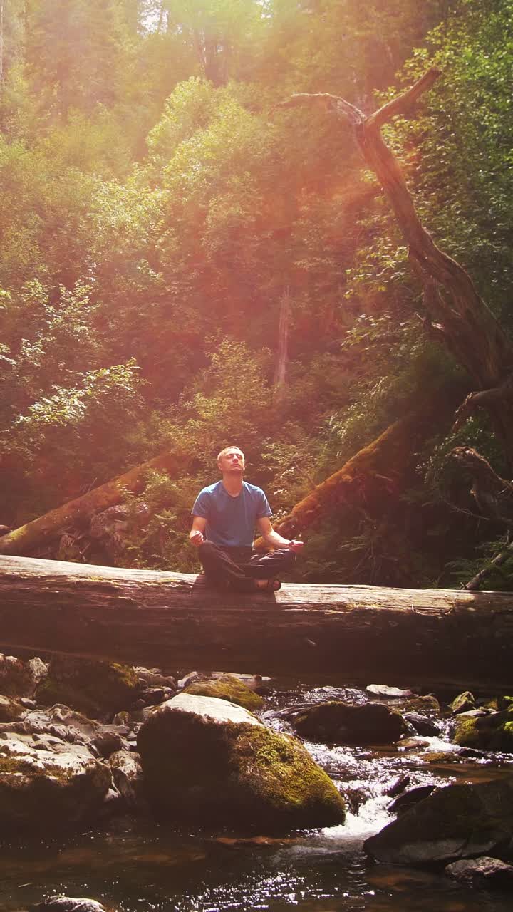 Man Meditating in a Forest by a Creek