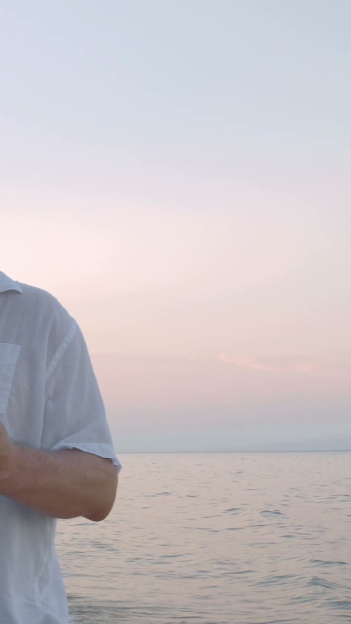 Man on Beach at Sunset Texting on Cellphone