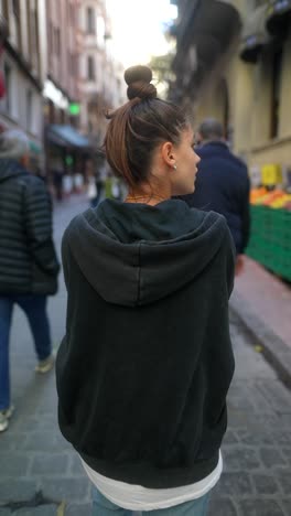 woman in a city street, exploring a fruit stand