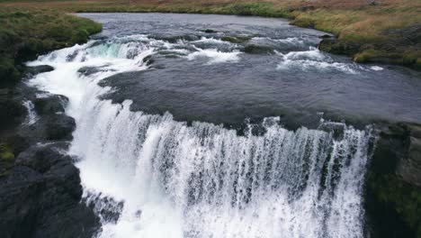 Aerial:-Reverse-reveal-of-Reykjafoss-cascading-waterfall-that-presents-itself-as-a-powerful-cascade-of-water