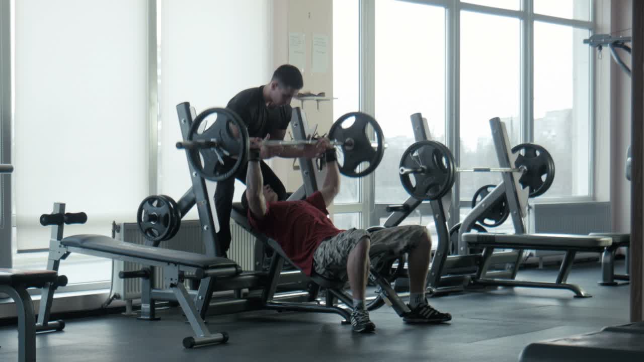 Man Getting Bench Press Help From Trainer in a Gym | Premium Stock ...
