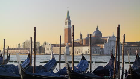 Góndolas-Cubiertas-Balanceándose-Sobre-El-Agua-Frente-A-Una-Hermosa-Vista-De-Venecia