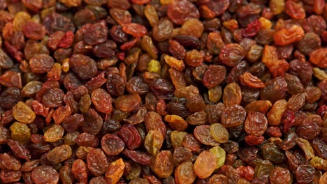 looped spinning full frame background of yellow and brown raisins pile