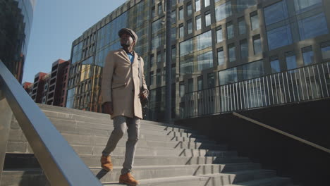 young african american businessman walking downstairs in city