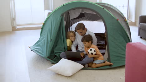 dad playing camping with kids at home