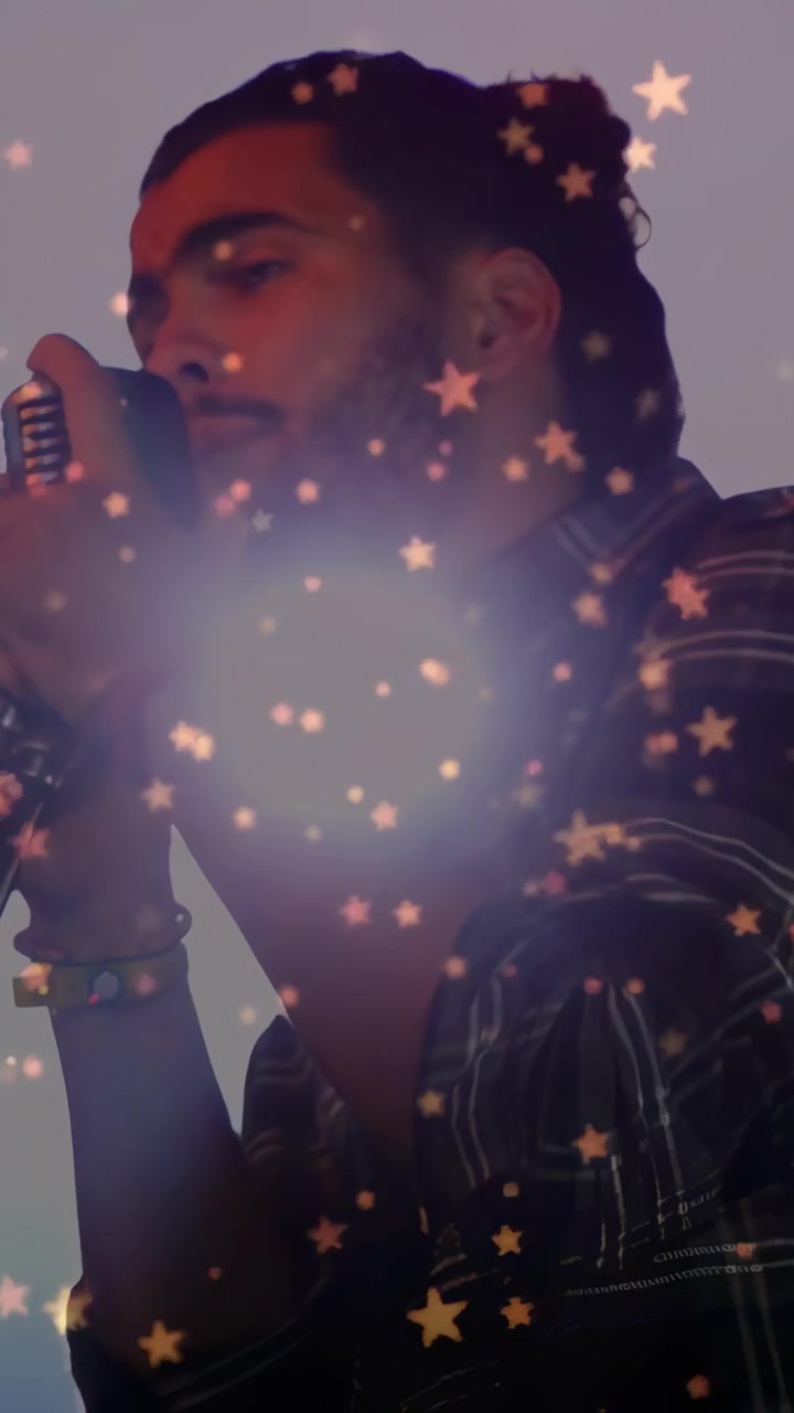 Vertical video: Male singer singing into vintage mic causing stars drifting then clearing for music