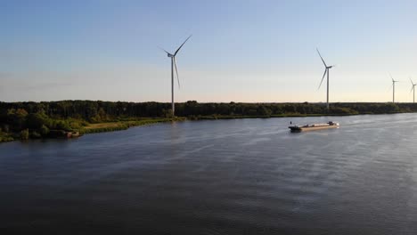 Aerial-Over-Oude-Maas-With-Still-Wind-Turbines-And-Silhouette-Of-Ship-Approaching-In-Distance