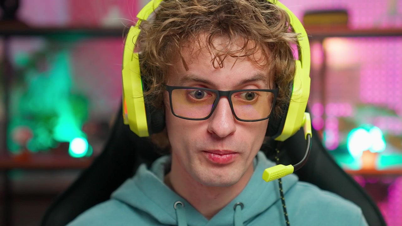 Soustředěný mladý muž s herními sluchátky mluví online