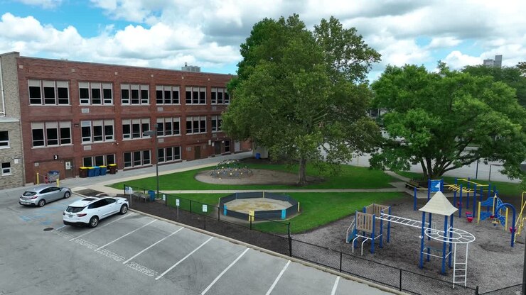 Brick American school with elementary school playground on beautiful day