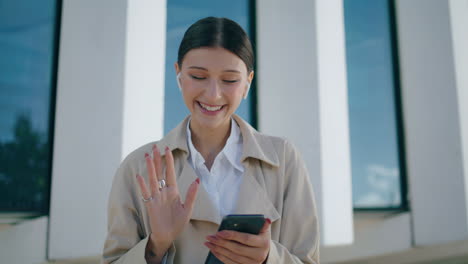 Woman-chatting-video-call-using-headphones-at-street-close-up-vertically-video