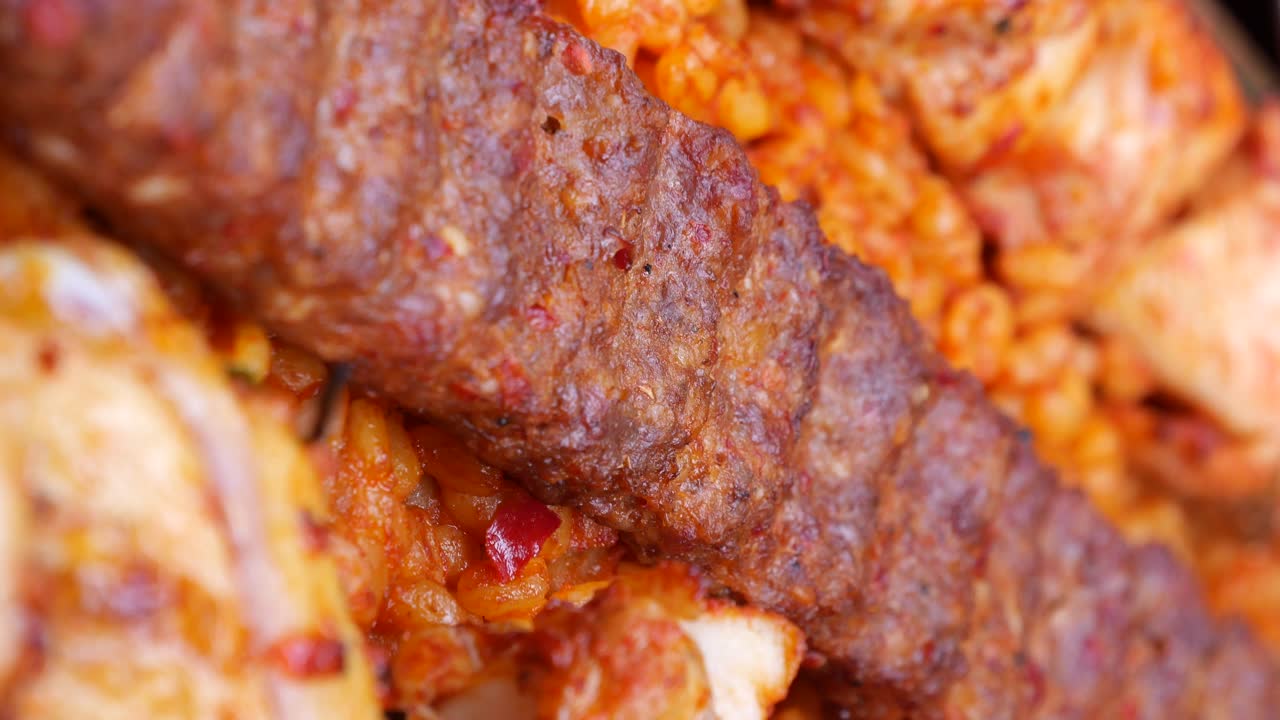 Close-up of Adana Kebab and other food items