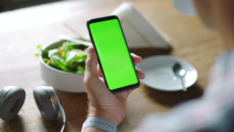 persona que utiliza un teléfono inteligente en un café