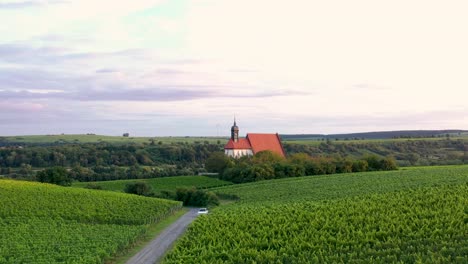 Drohnenflug-Knapp-über-Den-Weinbergen-Zu-Einer-Kleinen-Kirche-Im-Licht-Der-Abendsonne