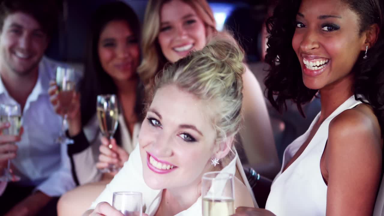 행복한 친구들이 리무진에서  ⁇ 페인을 마시고 있습니다.