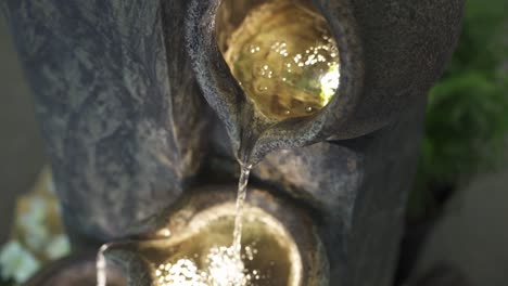 Beautiful-water-feature-with-trickling-drops-illuminated-by-led-lights-inside-concrete-bowls