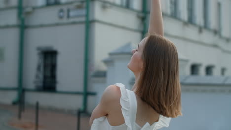 young woman posing outdoors in white dress