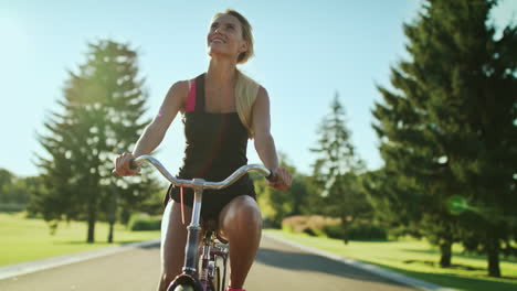 Mujer-Deportiva-Montando-Bicicleta-En-El-Parque-De-La-Ciudad-En-Un-Día-Soleado.-Ciclista-Feliz-Andando-En-Bicicleta