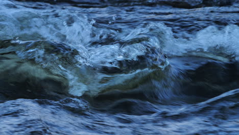 Closeup-detailed-footage-of-water-flowing-through-rapids-on-a-river-in-Northumberland,-England