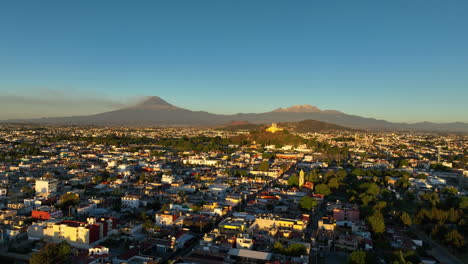 Drone-Elevándose-Sobre-El-Paisaje-Urbano-De-San-Andrés-Cholula,-Hora-Dorada-En-México