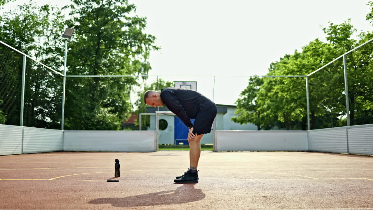 Un uomo sportivo in maglia e sneakers fa esercizi all'aperto. Un uomo fa sport su un parco giochi nel parco. Un uomo conduce uno stile di vita attivo. Un atleta fa esercizi all'aperto