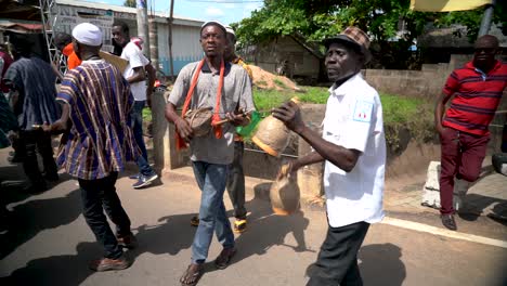 a group of street musicians play together in a festival parade in ghana, west africa.