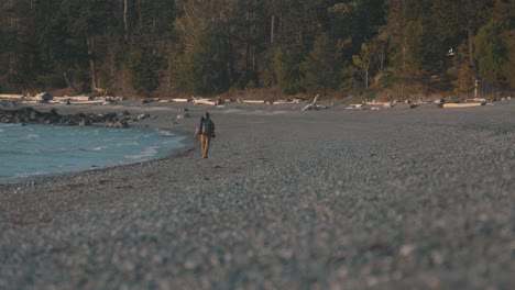 Excursionista-Camina-En-Una-Playa-Rocosa-En-La-Costa-Pacífica-De-La-Costa-Del-Sol,-Columbia-Británica,-Canadá