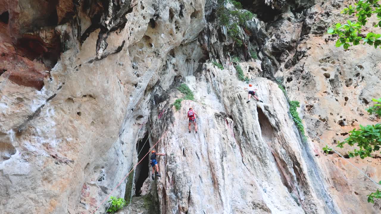 Climbers scale a cliff at Phra Nang Cave