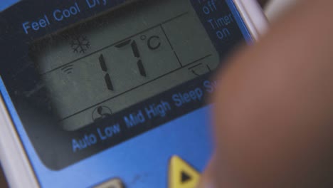 man switches on air conditioner with controller macro