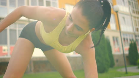 restoring strength after training. a woman wearing headphones warms up before training in the park. stretching outdoors.