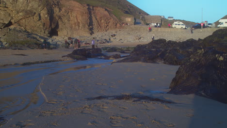 Vacacionistas-En-La-Playa-De-Chapel-Porth-Con-Aparcamiento-En-Cornualles,-Reino-Unido