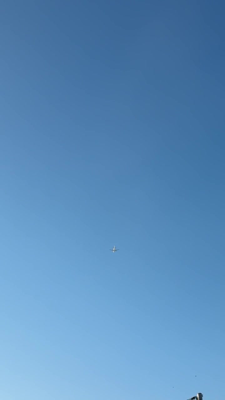 Aereo commerciale che vola alto in un cielo azzurro limpido