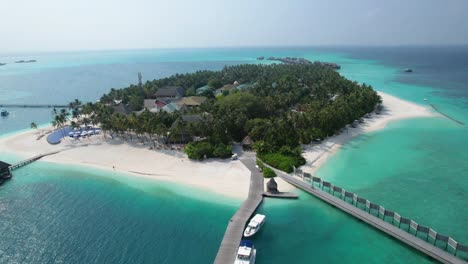 aerial view of tropical maldives resort island with boats pool beach and overwater buildings