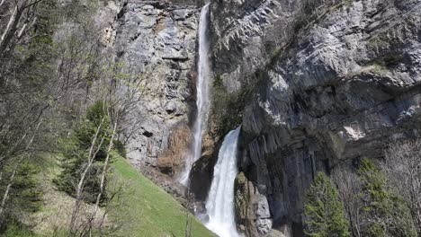 Sweeping-cascade-of-Seerenbachfälle-against-Swiss-cliffs,-a-natural-spectacle-of-Walensee-region---aerial