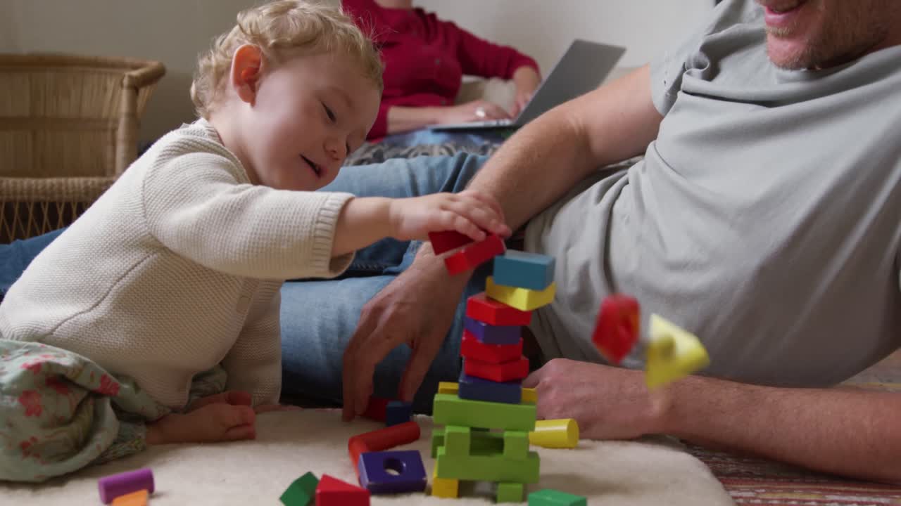hombre caucásico jugando con el bebé en casa