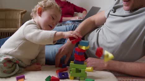 caucasian man playing with baby at home