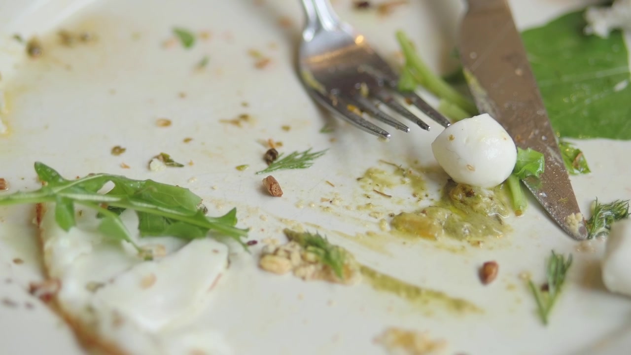 Avanzi di cibo su un piatto bianco con posate