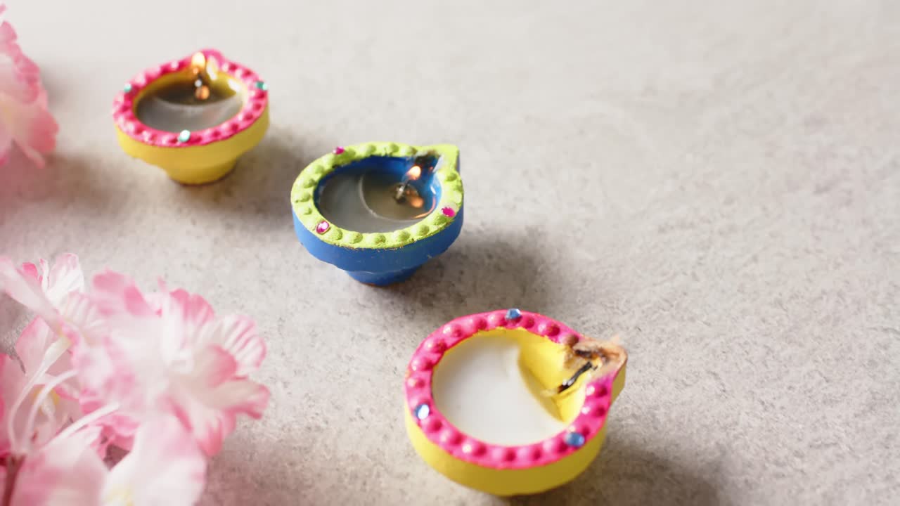 quemando velas coloridas celebrando diwali con espacio de copia y flores sobre un fondo blanco.