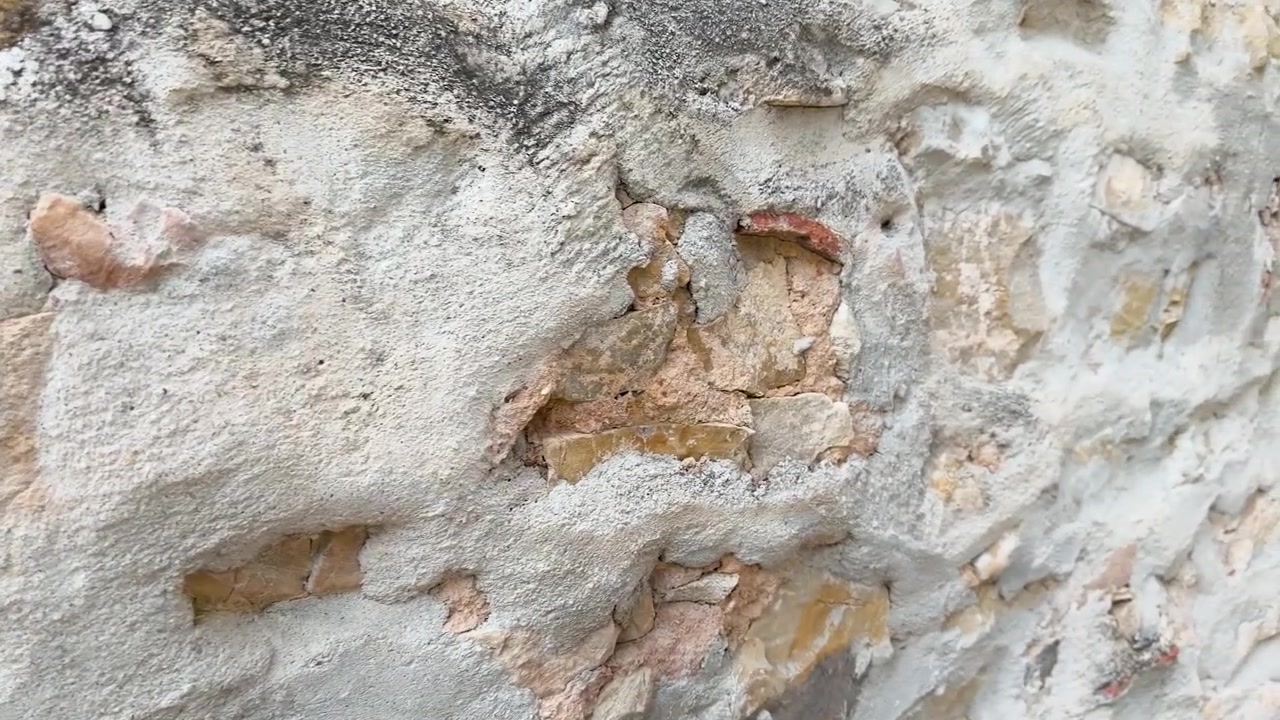 La telecamera a mano si muove lungo un antico muro di calcare eroso nel villaggio di Cassis.