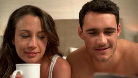 cute young couple reading newspaper