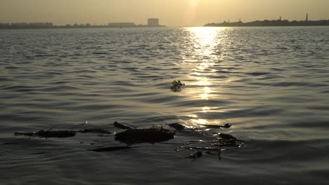 Statue-of-structure-floating-over-the-river-at-sunset