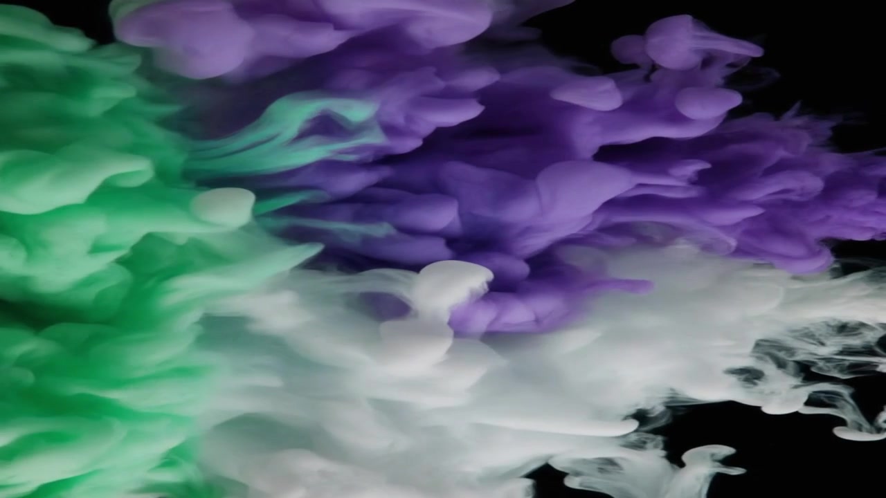 Nuvole di inchiostro verdi, viola e bianche che turbinano nell'acqua