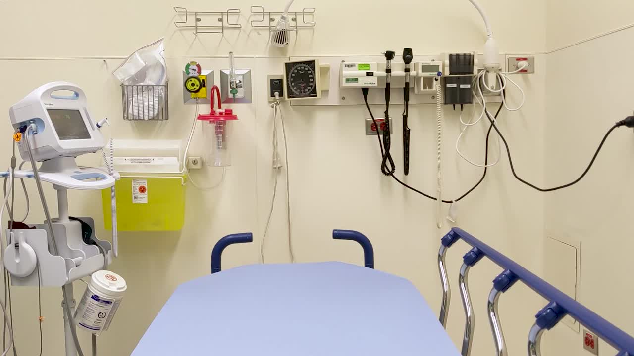 Dolly lento para a esquerda de uma sala de avaliação médica vazia, pronta para um paciente.
