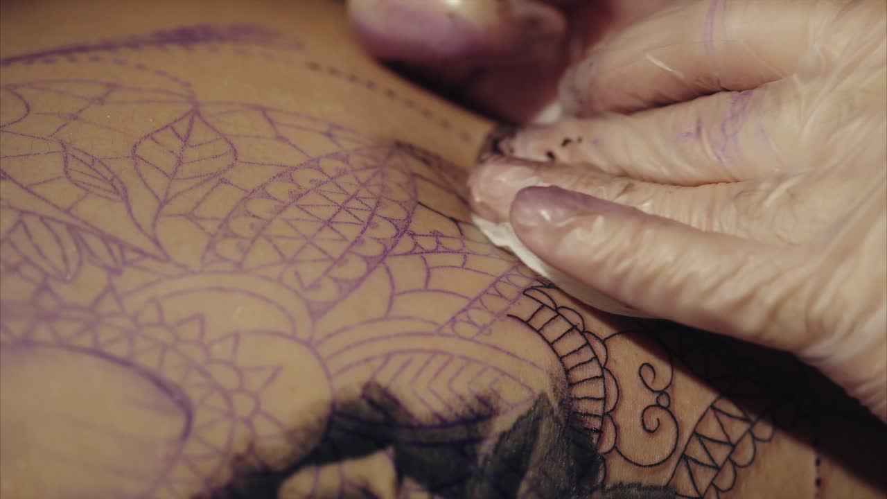 Tatuatore che lavora su un tatuaggio Mandala