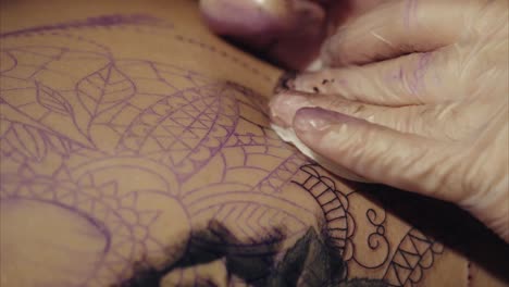 artista del tatuaje trabajando en un tatuaje de mandala