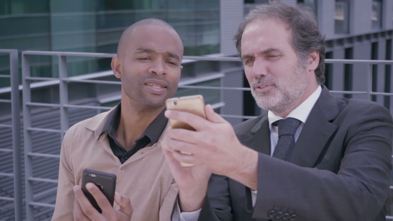 hombres de negocios profesionales discutiendo algo con teléfonos inteligentes en la ciudad