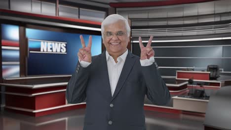 feliz periodista senior indio mostrando el signo de la victoria