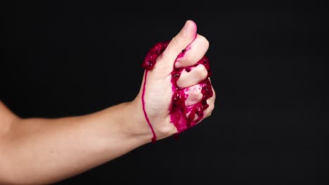 hand squeezing dragon fruit, juice dripping down