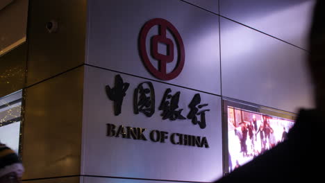 people walk past the bank of china building in manhattan