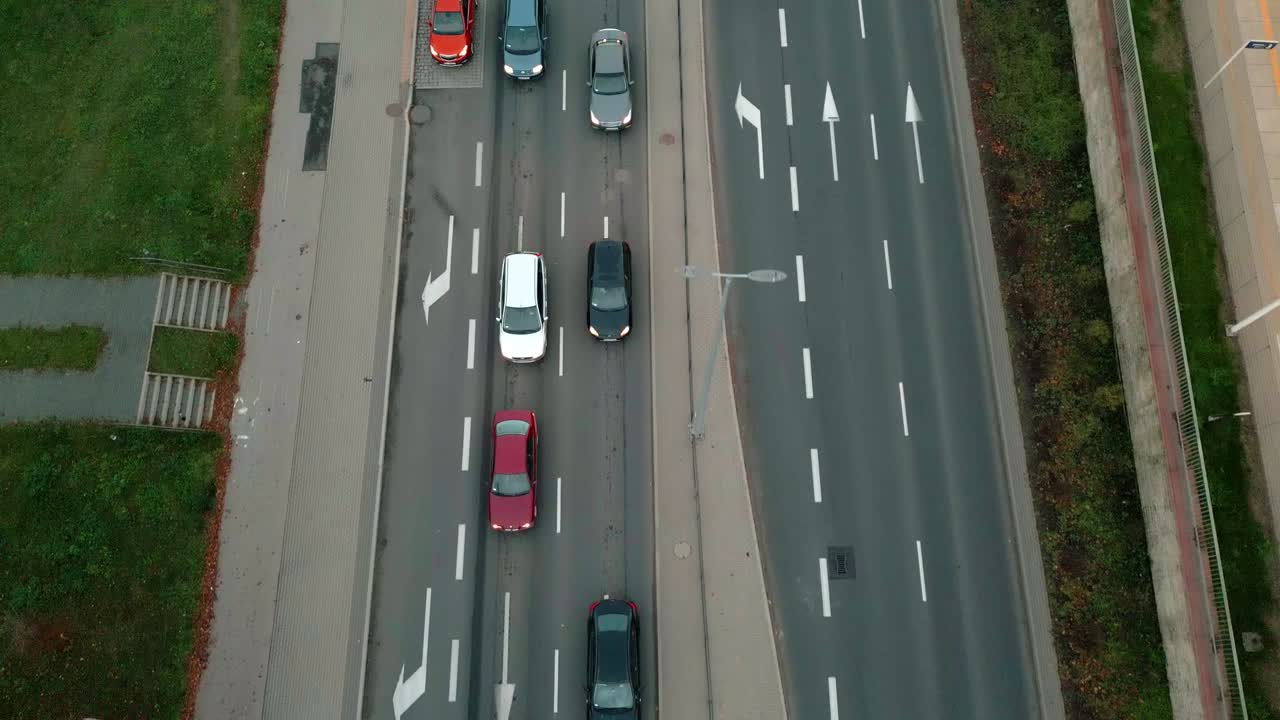 A dual-lane road in the city, with cars driving on it, seen from a bird's-eye view